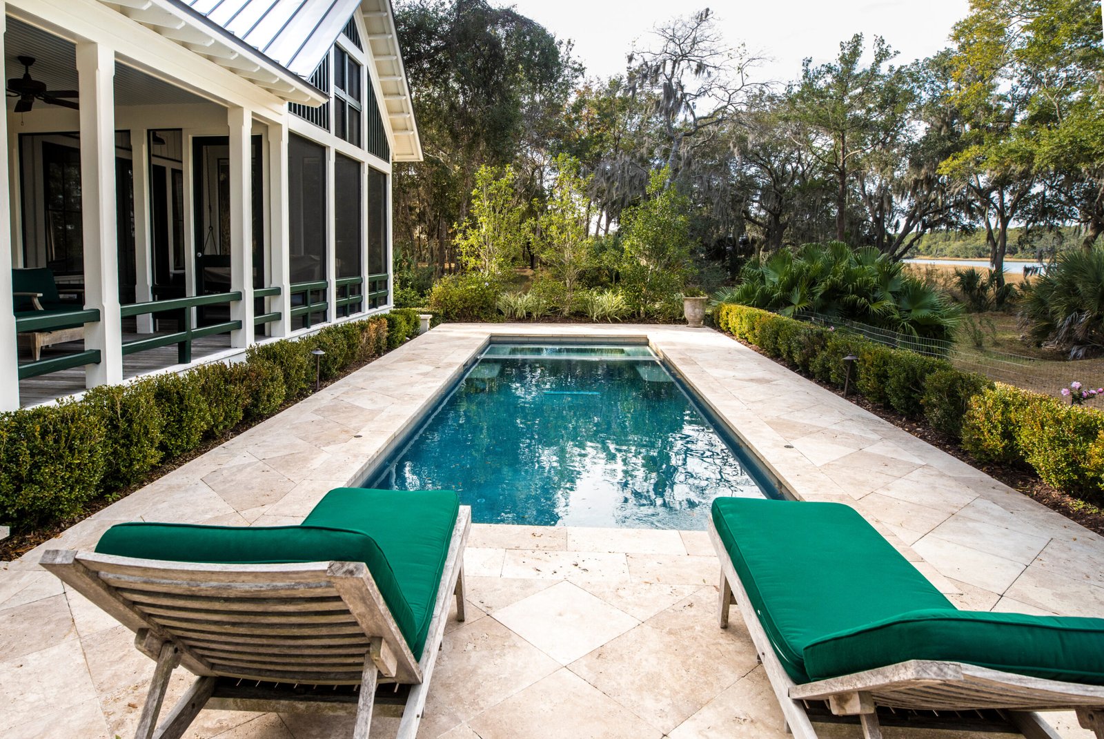 Beautiful back yard pool behind luxury home with garden.
